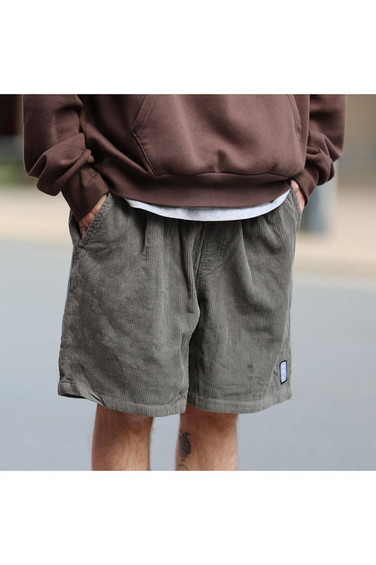 Bamboobay Olive Green Cord shorts on model with hand in pockets front view